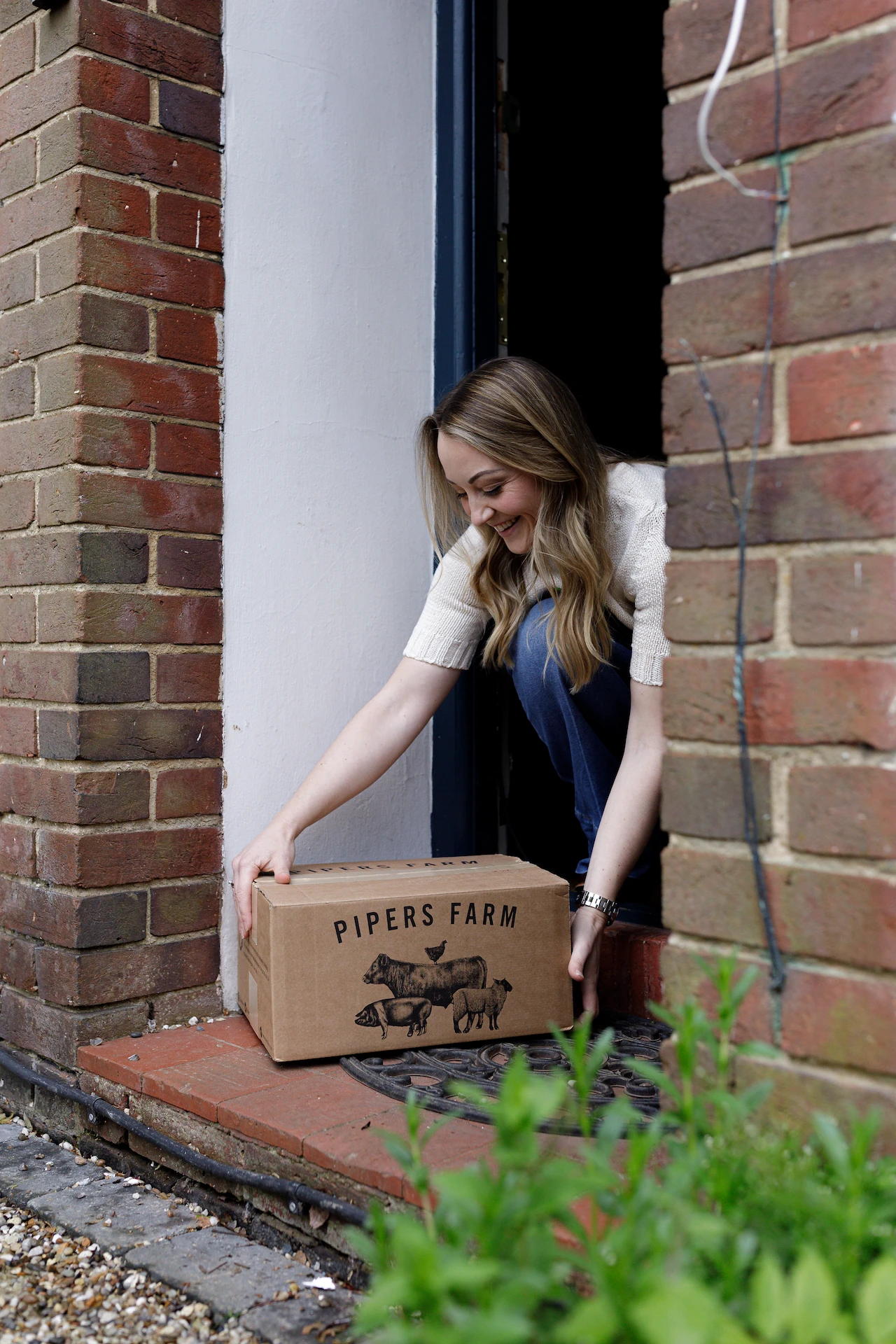 natalie picking up a box of vegetables